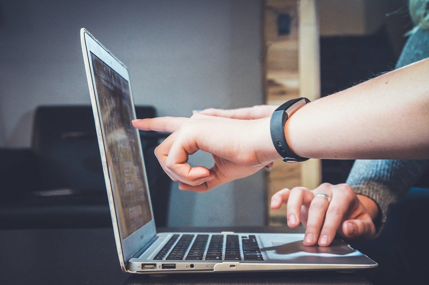 finger pointing to notebook screen in office meeting